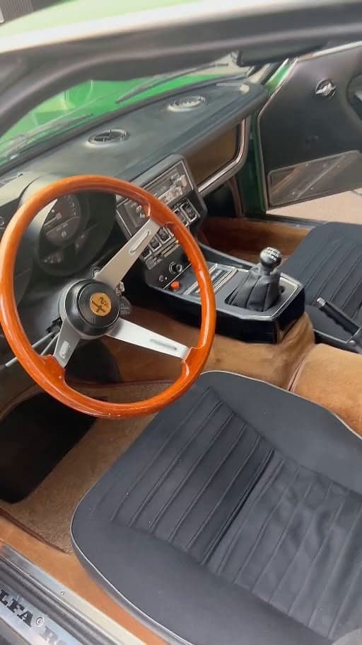 Innenraum eines grünen Alfa Romeo Oldtimers mit Holzlenkrad nach der Innenreinigung