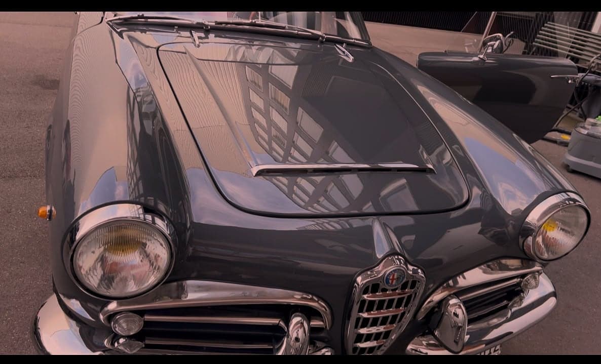 Front eines dunkelgrauen Alfa Romeo Oldtimers mit glänzendem Lack und poliertem Chrom nach der Aussenreinigung