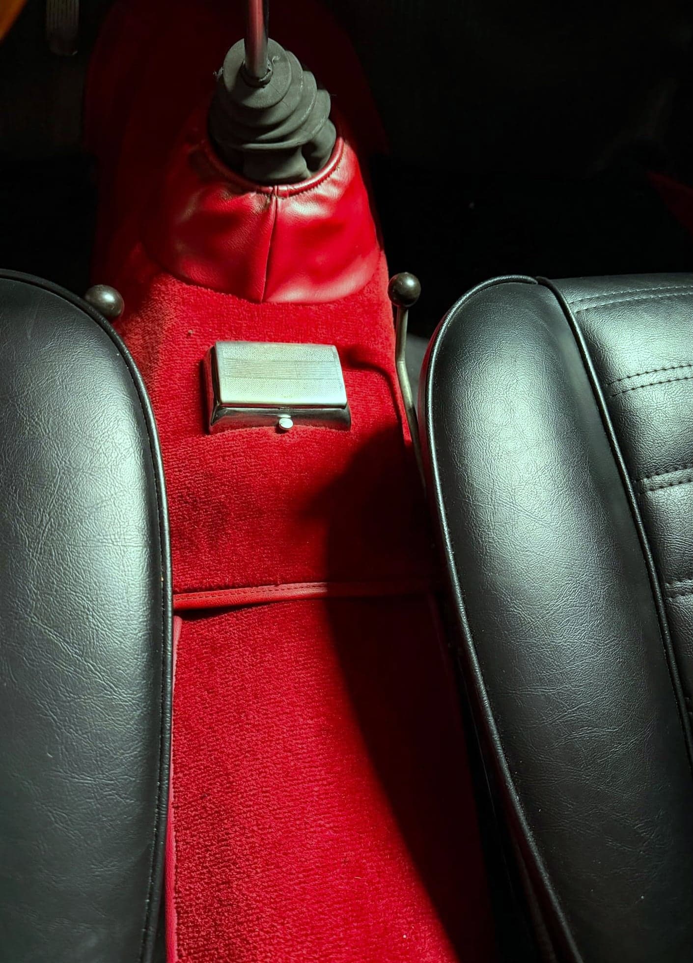 Roter Veloursteppich am Mitteltunnel eines dunkelgrauen Alfa Romeo Oldtimers nach der Teppichreinigung
